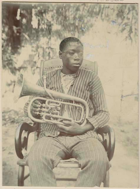 Man sitting and holding a brass musical instrument