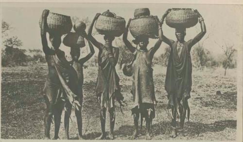 Four women and a child carrying baskets