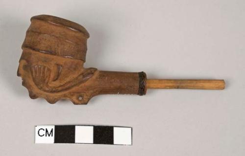 Carved wooden pipe with stem, bowl is carved likeness of man +