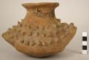 Unpainted pottery jar - body pointed at ends and covered with relief knobs; 2 pe