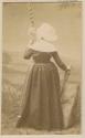 Studio portrait of a woman standing with her back to the camera