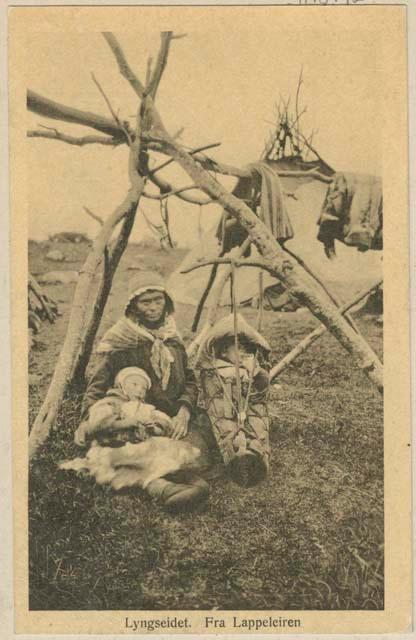 Woman with two babies, tent in background