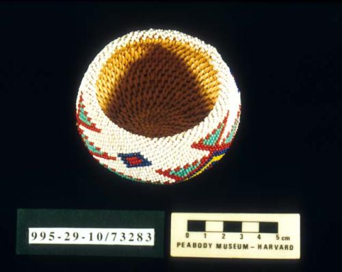 Coiled fully beaded trinket basket of willow with squash blossom motif