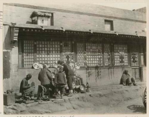 Group gathered near brass ware seller