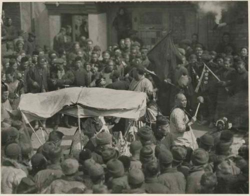 Dance of Chinese mummers in inn courtyard