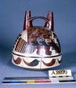 Double spout bottle painted in polychrome with "anth. mythical being" & peppers