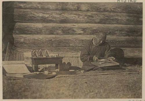 Man making charms in front of a building