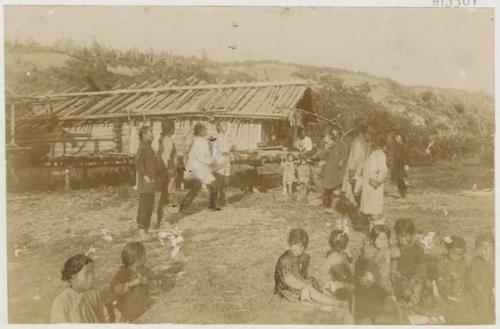 People playing ball in front of hut