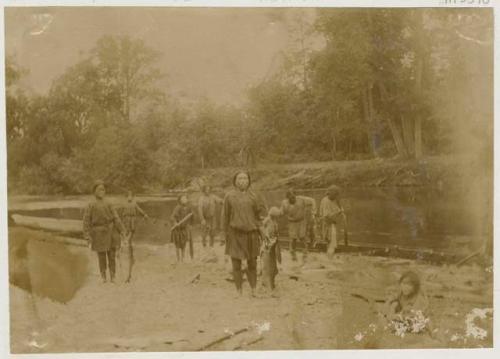 Group on riverbank, returning from fishing