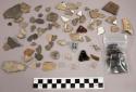 Limestone, stone chips, glass, black crystalline substance, pipe bowl fragment,