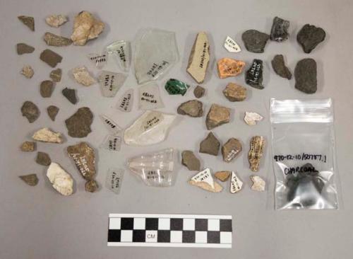 19 glass, 6 glass fragments, 4 pottery, 1 potsherd with blue glaze, stone chips,