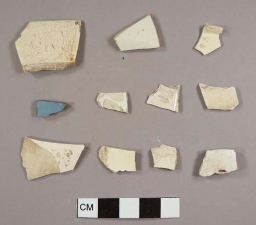 Creamware fragments, one with blue decoration, including one plate rim, one plate marly, and a footring base fragment possibly to a cup