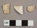 Kaolin/White ball clay pipe bowl fragments, two with ash residue on interior and one with "FR" stamped into the exterior