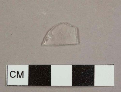 Colorless, curved glass fragment, possibly from a lamp chimney