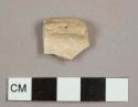 Earthenware base sherd to a hollowware vessel, possibly tin-glazed earthenware but no glaze remaining