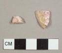 Earthenware sherds, including one possible kaolin pipe bowl stem and one whiteware saucer or bowl rim sherd with pink sponge-painted decoration on interior