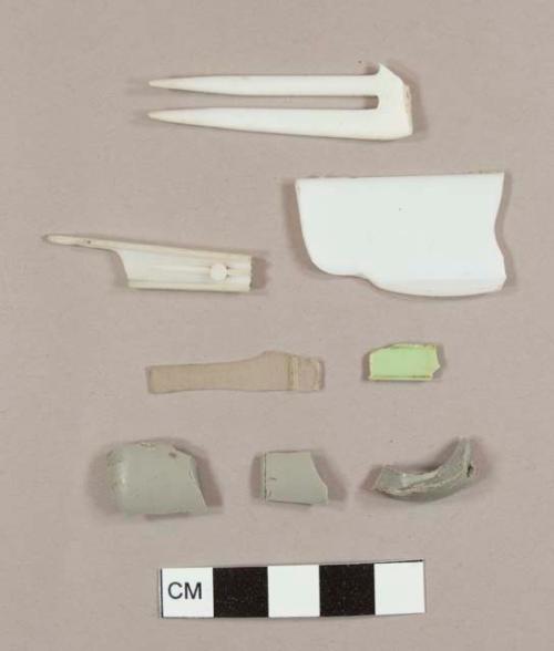 Miscellaneous grey, green, and white plastic fragments, including one utensil handle fragment