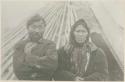 Man and woman in front of hut