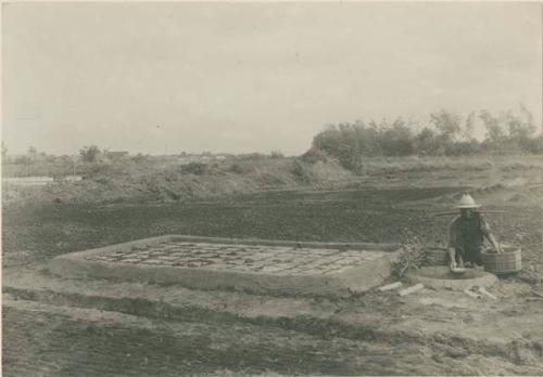 Man dips up brine from a completed leach