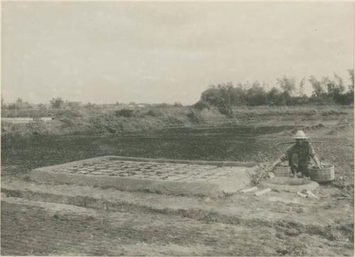 Man dips up brine from a completed leach