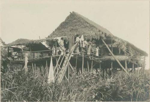 Group of Subano people on platform in front of house