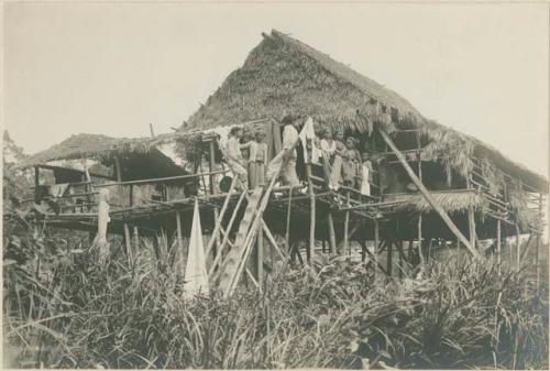 Group of Subano people on platform in front of house