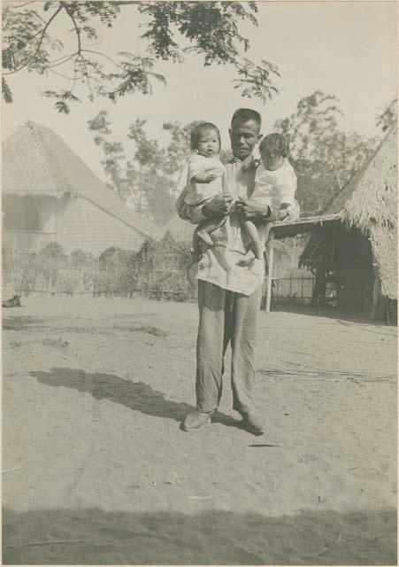 Tagalog man carrying two babies