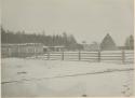 Buildings and fence covered with snow