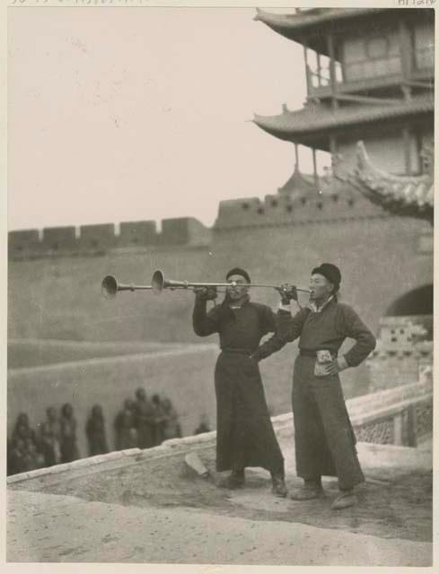 Two trumpeters playing their long trumpets