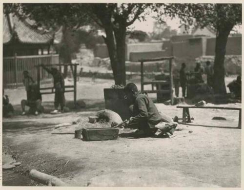 Tinsmith sitting and plying his trade in Market Square