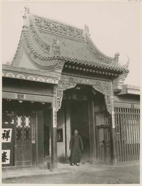 Man standing outside entrance to the shop of a large Chinese trading company