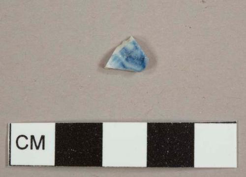 Porcelain sherd with handpainted blue decorations on one side
