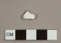 Whiteware sherd with blue decoration on one side, possibly transfer print