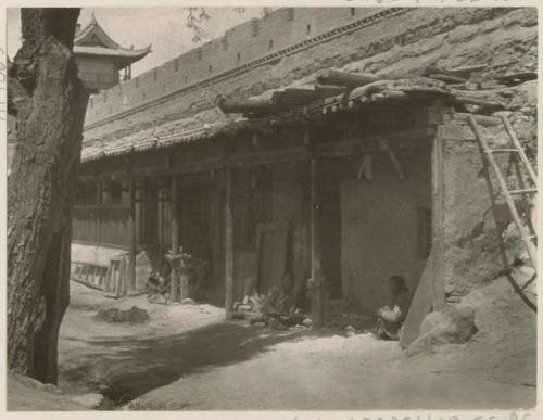 Boys sitting outside carpenter shop