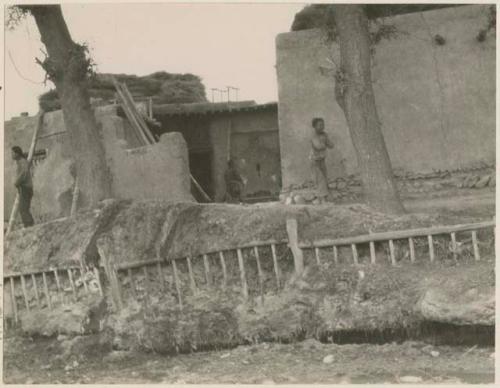 Side street, with wooden poles keeping th bank from caving into the irrigation ditch below