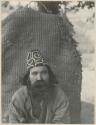 Bearded man in front of woven straw object