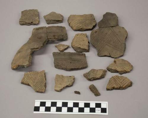 Ceramic, earthenware rim and body sherds, incised and cross-hatch incised decoration; one perforated rim sherd, two crossmended