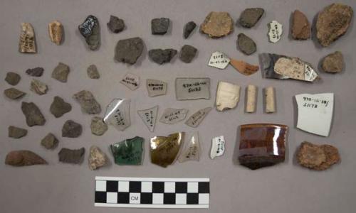 8 glass, 3 glass fragments, 21 pottery, 1 potsherd with blue glaze, 3 pipe fragm