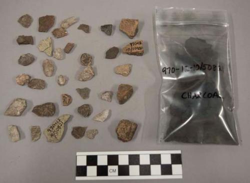 30 fragments quartz and limestone; 8 fragments pottery; fragments coal-like subs