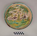 Pedestalled majolica plate: tin-glazed earthenware with picture of wolf chasing