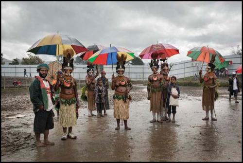 Color image: Sing-sing performers taking cover from heavy rain inside the Wabag Stadium during the annual Enga Show