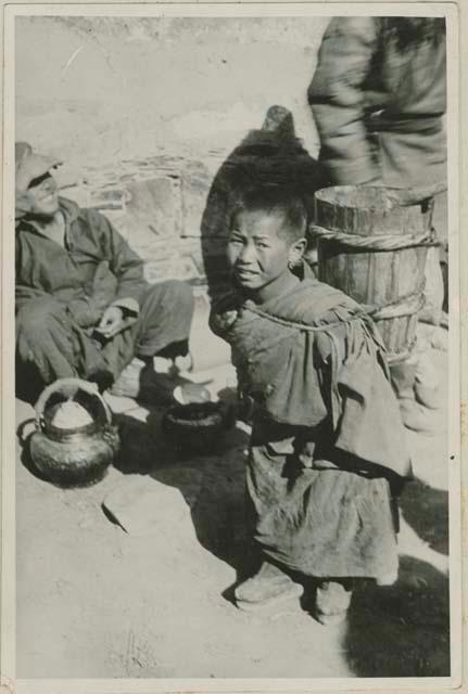 Young lama carrying water