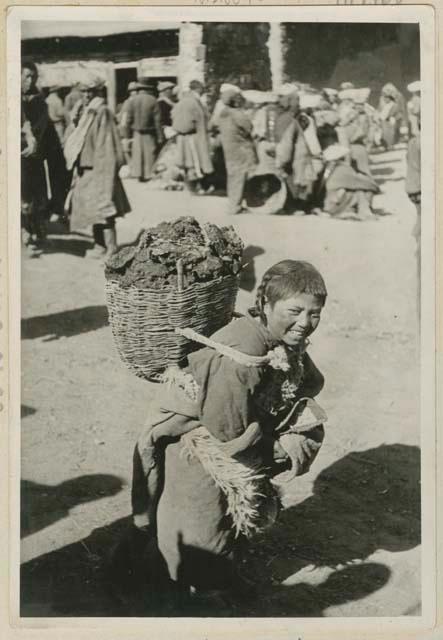 Boy carrying backet of argols