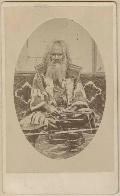 Ainu chief wearing jiinbaori, with his treasures before him