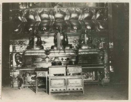 Votive offerings at base of idol