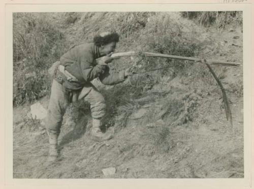 Salar aiming a rifle outside