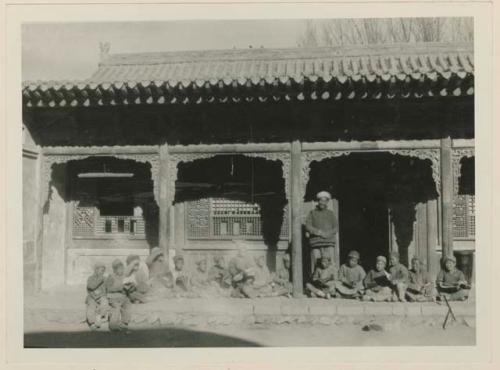 Salar teacher and students holding books in front of a school