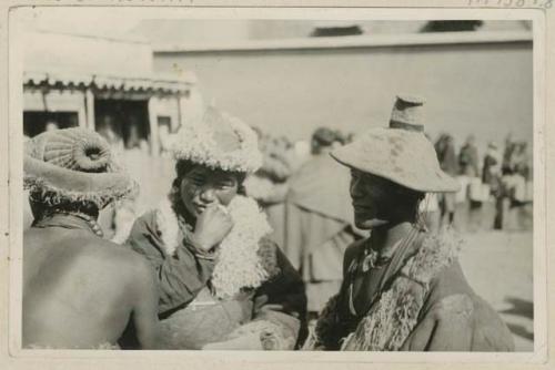 Three people standing outside wearing hats