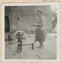 Woman spinning with a spinning wheel outside a building