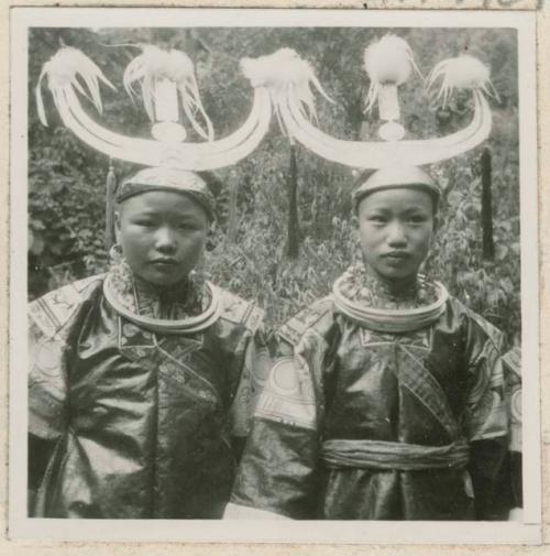 Two girls standing outside wearing headdresses